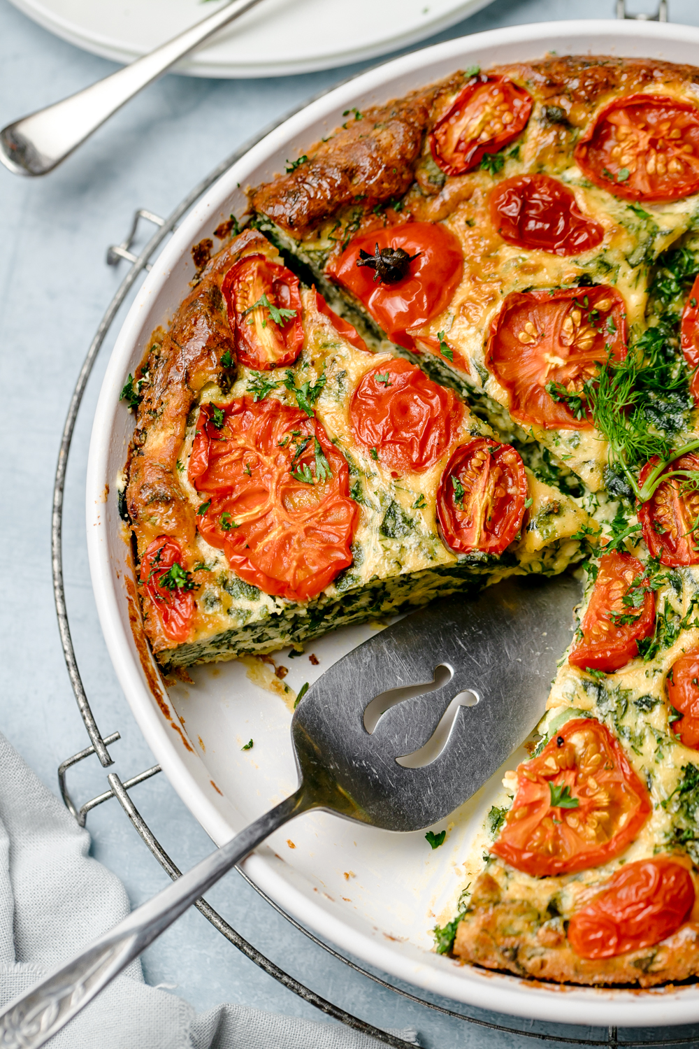 Close up of crustless pie made with eggs, ricotta, kale and tomatoes on top