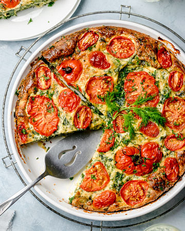 Top down view of a crustless pie made with eggs, ricotta, kale and tomatoes