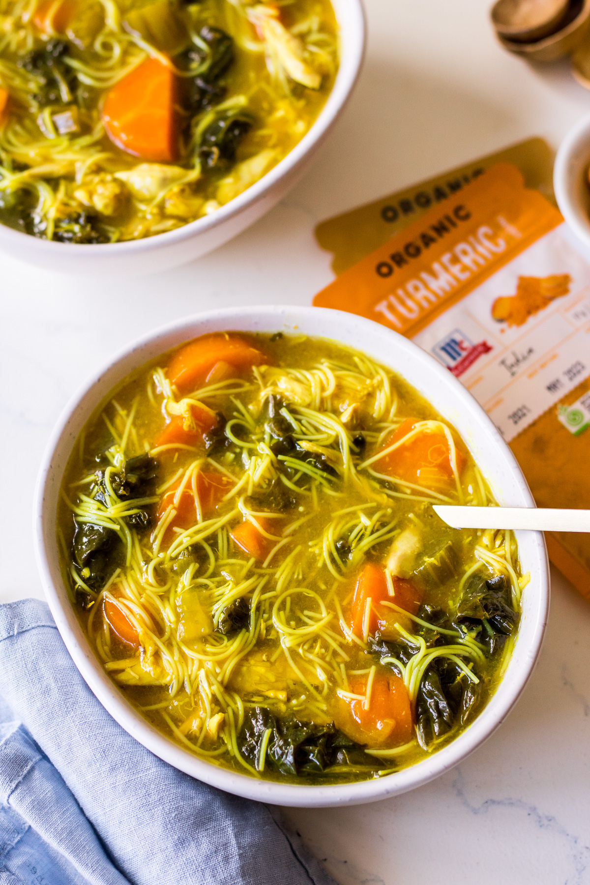 Bowl of chicken noodle soup with kale and turmeric with McCormick Spices