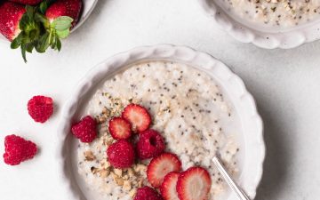Bowl of oat and chia seed porridge topped with sliced strawberries