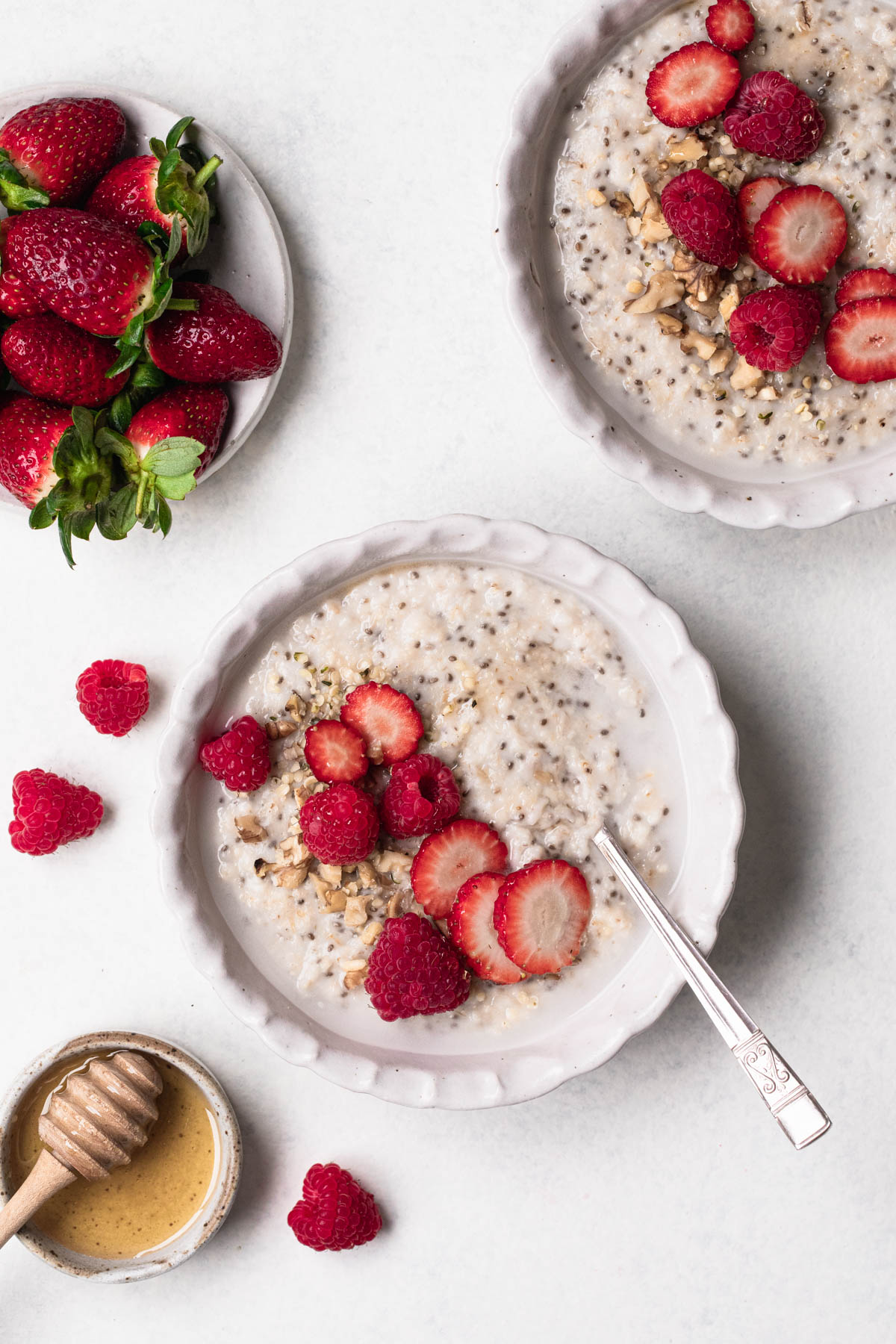 Bowl of oat and chia seed porridge topped with sliced strawberries