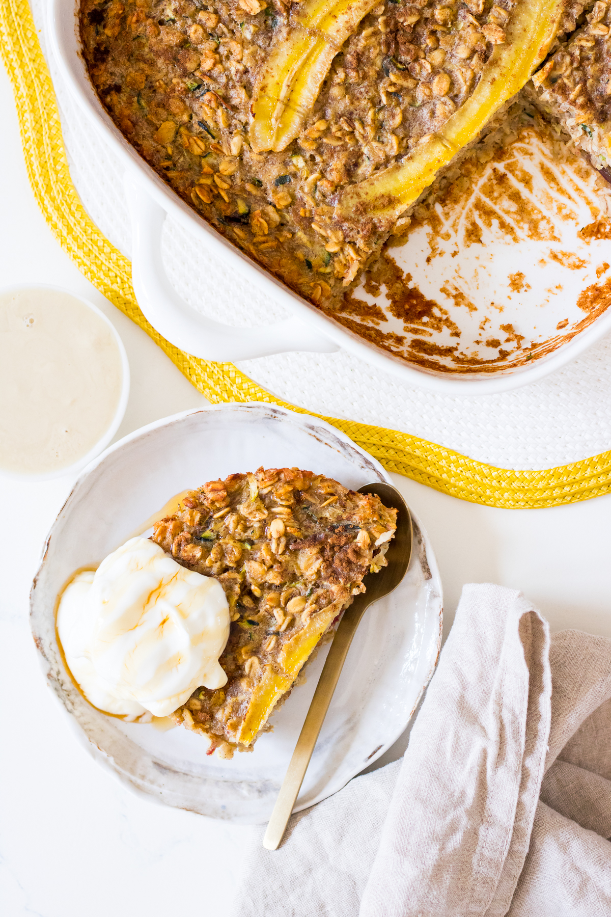 Close up of a serve of banana zucchini baked oats on a small white plate