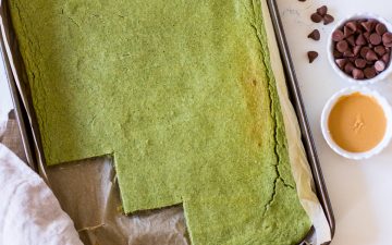 Image of healthy green pancakes baked in a baking tray, the edge cut into squares