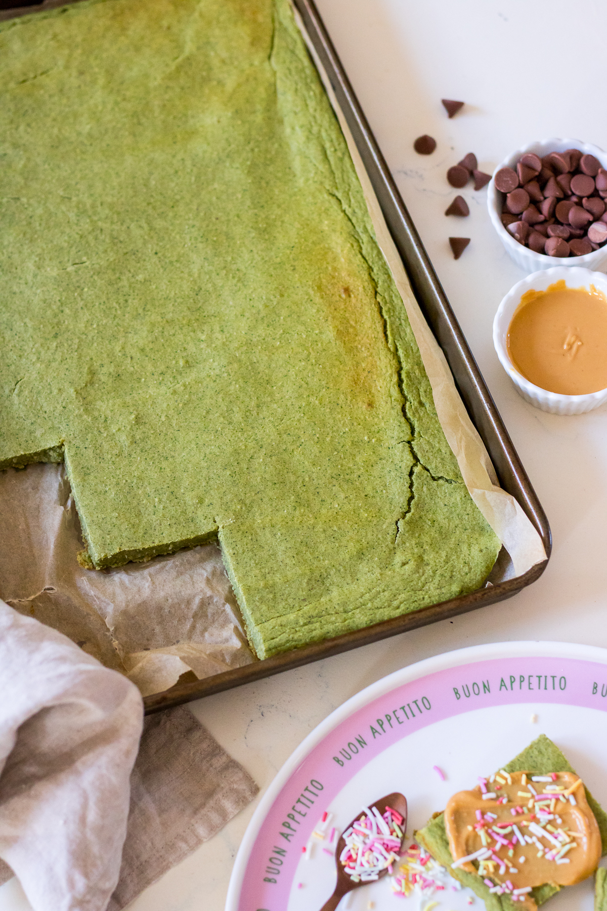 Image of healthy green pancakes baked in a baking tray, the edge cut into squares