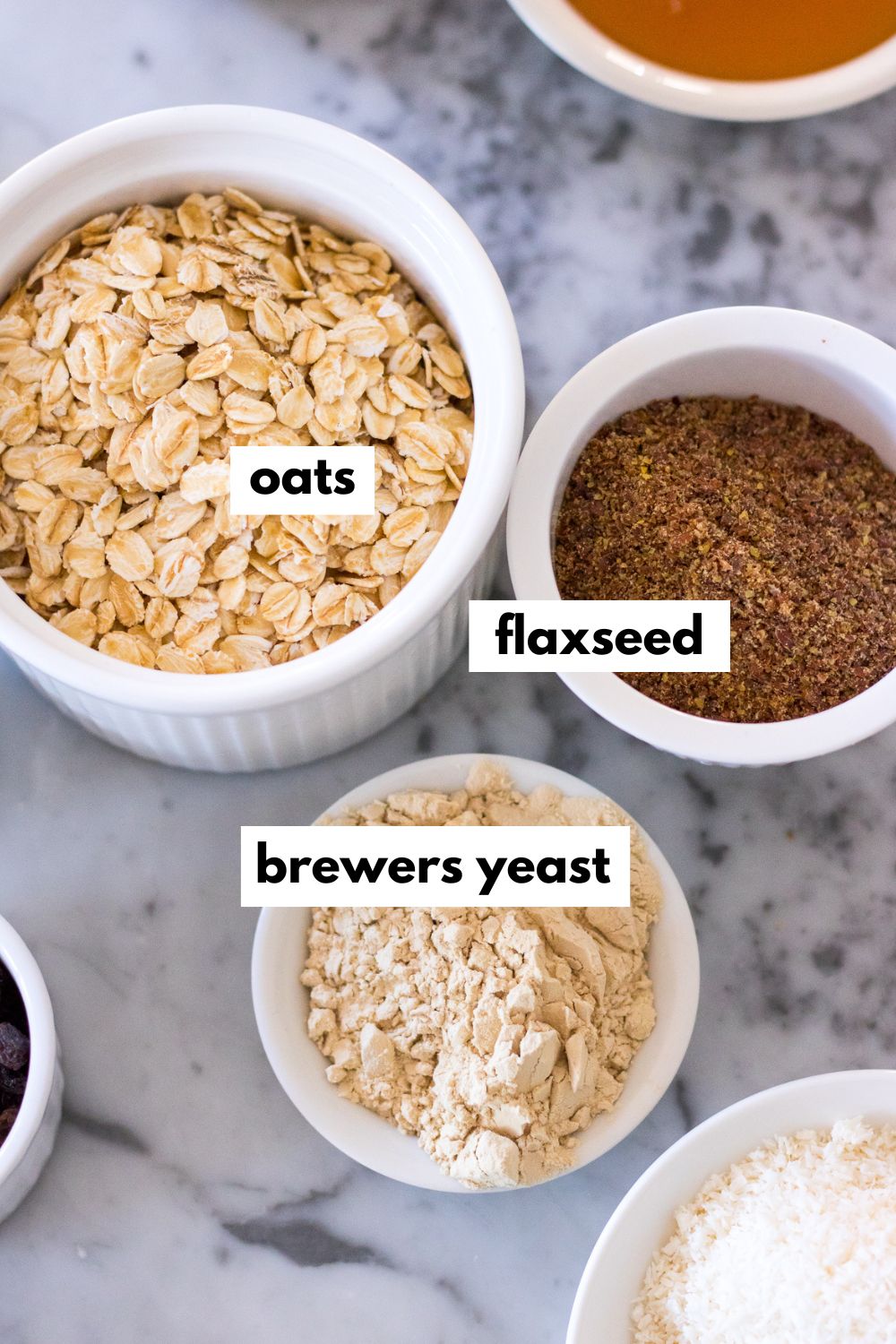 an image of small ceramic dishes filled each with oats, ground flaxseed and brewers yeast powder