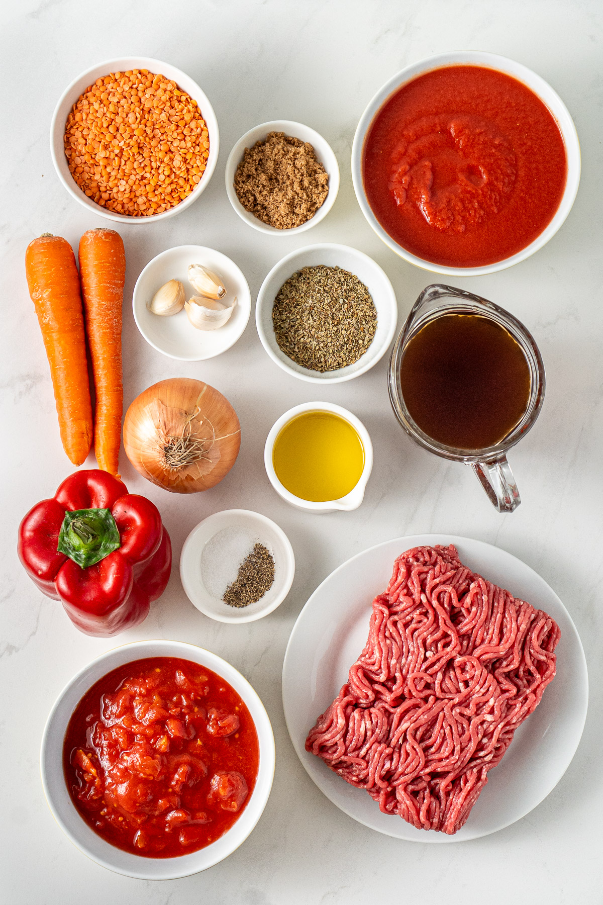 Ingredients needed to make a healthy homemade bolognese sauce with lean beef mince, red lentils, passata and vegetables.