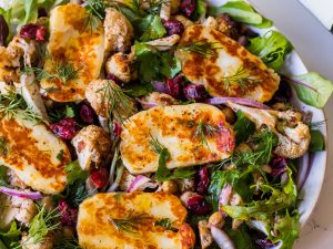 Close view of roasted cauliflower salad topped with fried halloumi slices