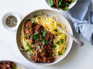 Red Wine Bolognese in ceramic bowl, spaghetti, parsley garnish